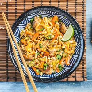 Wok de poulet au curry rouge, gingembre et cacahuètes